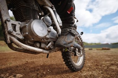 Motosikleti dışarı fırlatırken pedala basan tanınmamış motosikletlinin yakın çekimi.