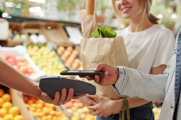 Zbliżenie Młodych Par Płacących Świeże Produkty Smartfonem Rynku Żywności Ekologicznej — Zdjęcie stockowe