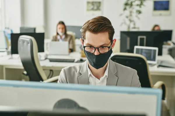 Joven Empresario Contemporáneo Gafas Máscara Textil Negra Protectora Mirando Pantalla — Foto de Stock