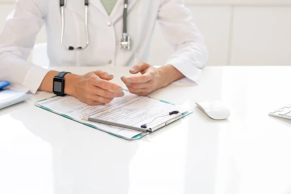 Manos Joven Clínica Whitecoat Sentada Junto Escritorio Consultando Alguien Mientras — Foto de Stock