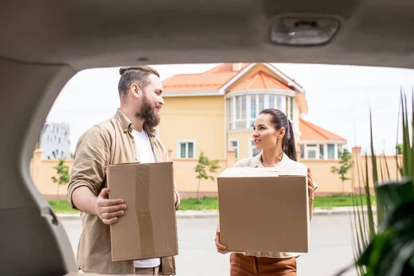 Pareja Joven Sosteniendo Cajas Cartón Cargando Carro Mientras Sale Casa — Foto de Stock