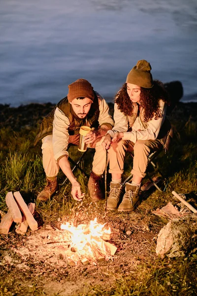 Jeunes Randonneurs Assis Coin Feu Camp Soir Sur Fond Rivière — Photo