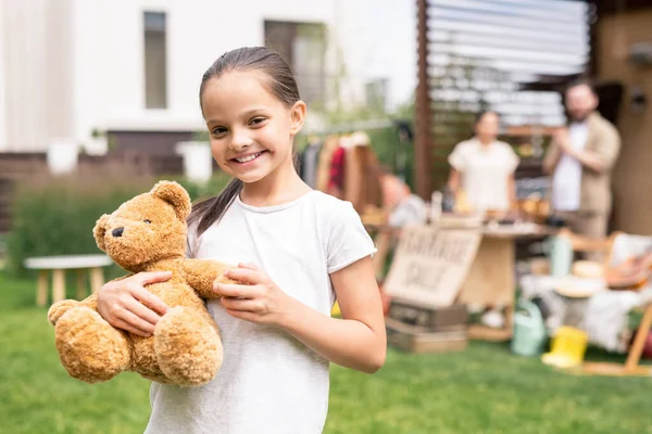 Retrato Sorrir Menina Bonita Abraçando Brinquedo Urso Comprado Venda Garagem — Fotografia de Stock