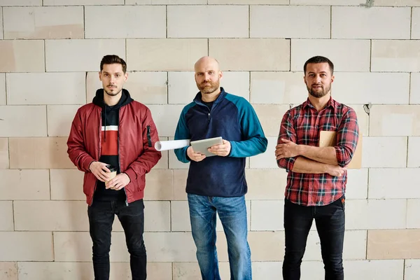 Três Jovens Trabalhadores Casualwear Contra Parede Tijolo Branco Construção Inacabada — Fotografia de Stock