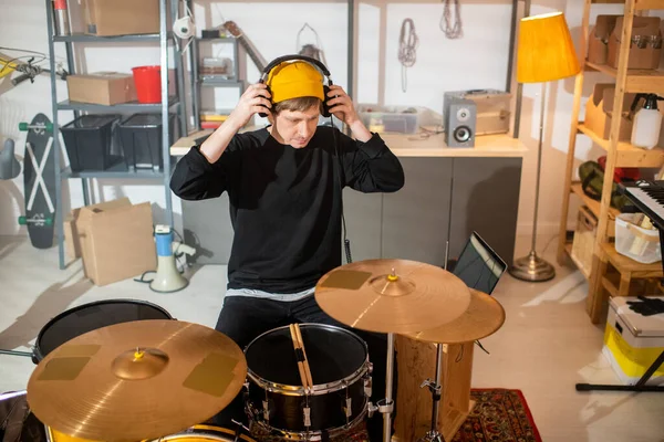 Contemporary Young Musician Casualwear Putting Headphones While Sitting Drum Kit — Stock Photo, Image