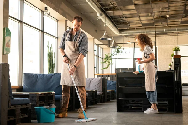 Busy Young Couple Aprons Washing Floor Cleaning Surfaces Detergent While — Stock Photo, Image