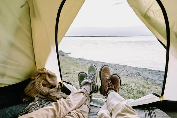 夏の週末にハイキングをしながら 海辺の前にオープンテントの中に横たわっているカジュアルウェアの若い香りのカップルの足 — ストック写真