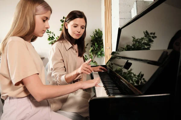 Mujer Morena Joven Señalando Tecla Del Piano Mientras Consulta Enseña —  Fotos de Stock
