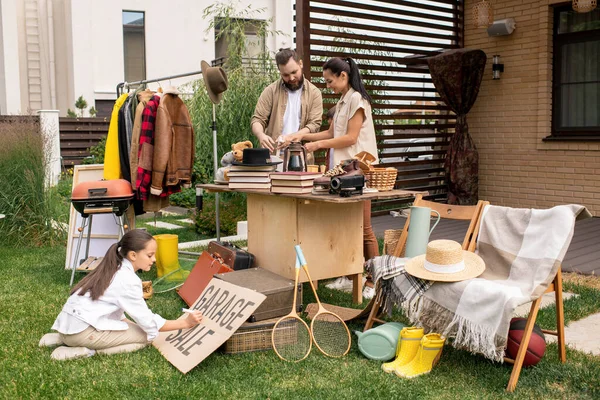 Junge Eltern Sortieren Sachen Auf Dem Tisch Für Den Garagenverkauf — Stockfoto
