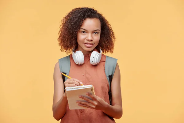 Portret Uśmiechniętej Ciekawej Afroamerykańskiej Studentki Kręconymi Włosami Noszącej Słuchawki Bezprzewodowe — Zdjęcie stockowe