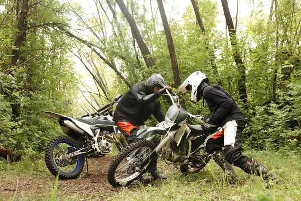 Hommes Forts Dans Les Casques Ramasser Moto Ensemble Dans Forêt — Photo