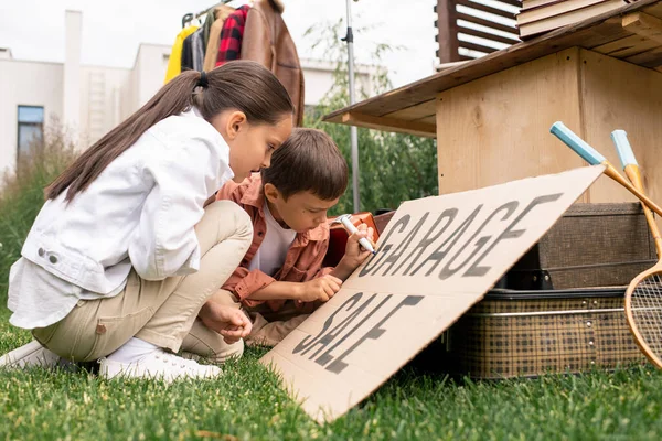 Creative Cute Kids Sitting Grass Making Garage Sale Sign Together — Stock Photo, Image