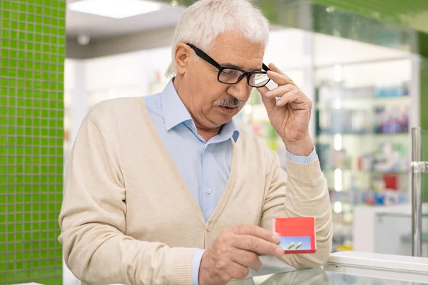 Contemporary Senior Man Eyeglasses Casualwear Looking Red Package New Medicine — Stock Photo, Image