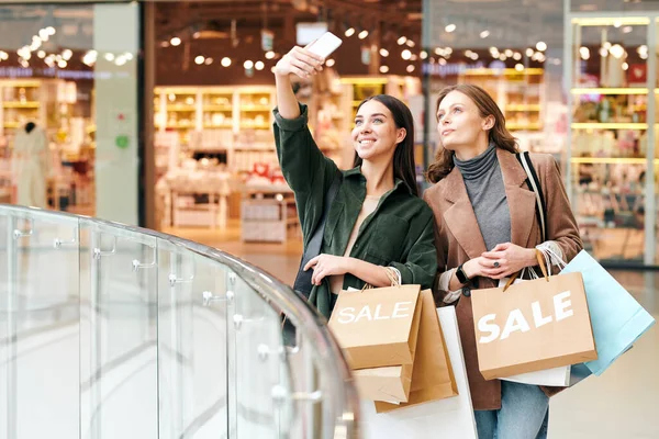 Fiatal Vidám Okostelefonnal Papírzacskókkal Szelfit Készít Egy Barátjával Aki Mellette — Stock Fotó