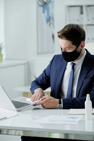 Jovem Empresário Terno Máscara Facial Sentado Mesa Desinfetando Laptop Com — Fotografia de Stock