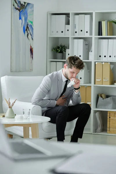 Joven Empresario Enfermo Sentado Sillón Oficina Tosiendo Servilleta Mientras Siente — Foto de Stock