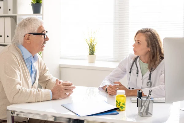 Mladý Blonďatý Doktor Lékařského Poradce Který Sedí Pracovišti Mluví Starším — Stock fotografie