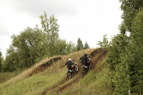 Widok Tyłu Ekstremalnych Motocyklistów Kaskach Osiągających Prędkość Podczas Wspinaczki Wzgórzu — Zdjęcie stockowe