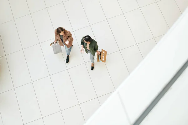 Przegląd Dwóch Młodych Przyjaznych Kobiet Konsumentów Napojami Papierowymi Torbami Poruszającymi — Zdjęcie stockowe