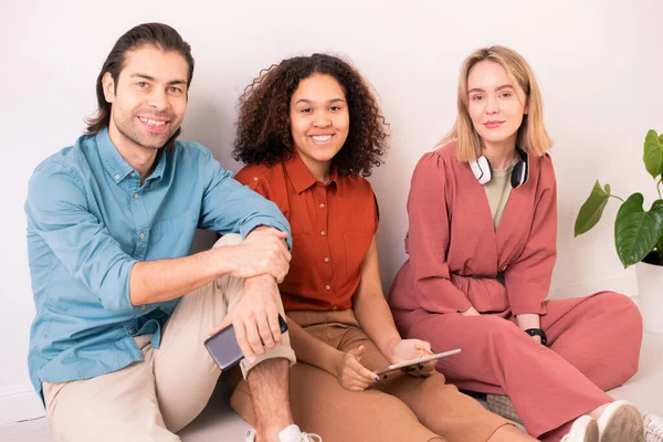 Three Young Cheerful Friends Casualwear Sitting Wall Studio Using Modern — Stock Photo, Image