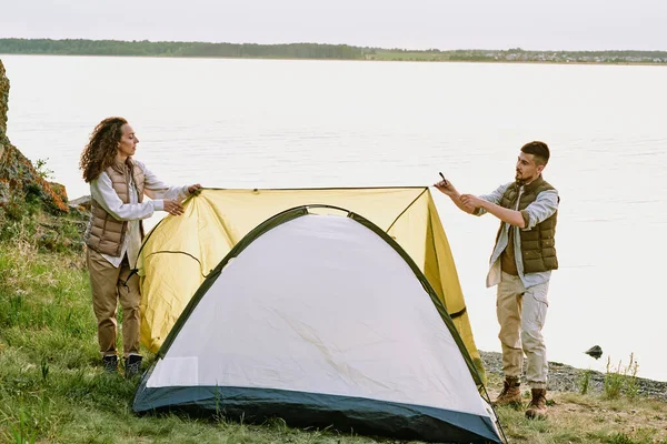 Současní Mladí Turisté Kladou Stan Zem Vody Natahují Textilní Střechu — Stock fotografie