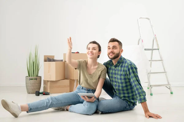 Positivo Jovem Casal Sentado Chão Novo Apartamento Com Coisas Movimento — Fotografia de Stock