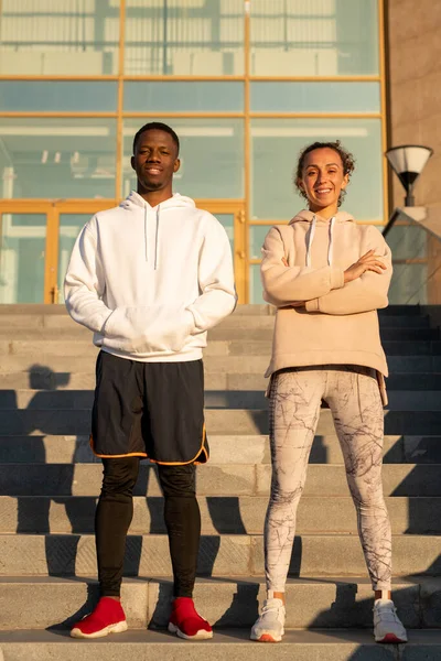 Jovem Feliz Intercultural Casal Desportivo Activewear Contra Escadaria Arquitetura Moderna — Fotografia de Stock