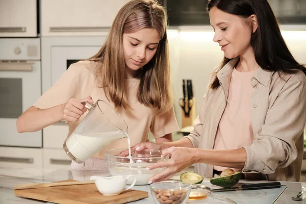 Mãe Bonita Sua Filha Adolescente Bonito Mesa Cozinha Derramando Leite — Fotografia de Stock