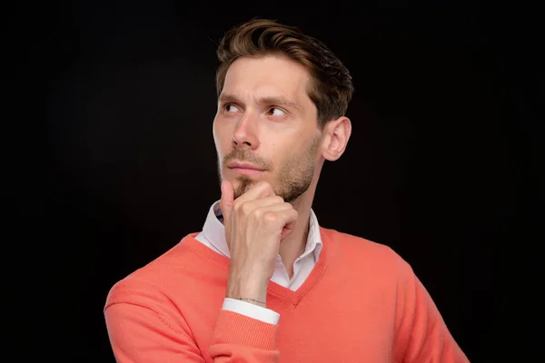 Pensive Handsome Young Man Orange Sweater Rubbing Chin While Thinking — Stock Photo, Image