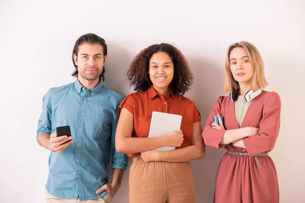 Hombre Joven Con Teléfono Inteligente Dos Chicas Interculturales Con Dispositivos —  Fotos de Stock