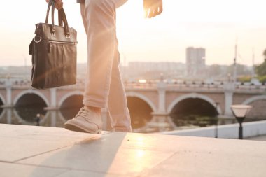 Kimliği belirsiz bir adamın evrak çantası taşıdığı ve sabah işe giderken merdivenlerden çıktığı yakın plan.