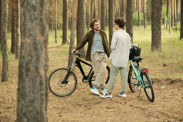 Genç sakallı adam yaz tatilinin keyifli anlarından bahsederken kız arkadaşına bakıyor.