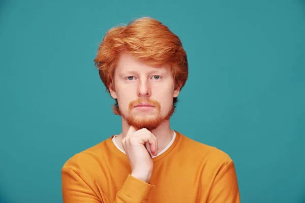 穿着橙色毛衣的英俊红头发男子 手指头靠近嘴 同时要求保持冷静 — 图库照片