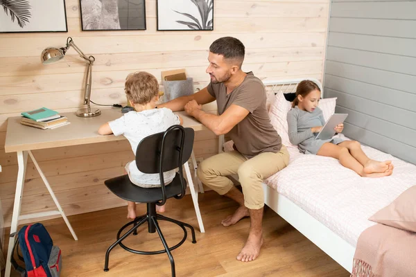 Young Man Casualwear Helping His Cute Little Son Homework Wooden — ストック写真