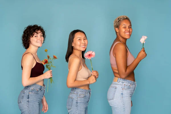 Tři Mladé Veselé Ženy Tanktopech Modré Džíny Drží Čerstvé Květiny — Stock fotografie