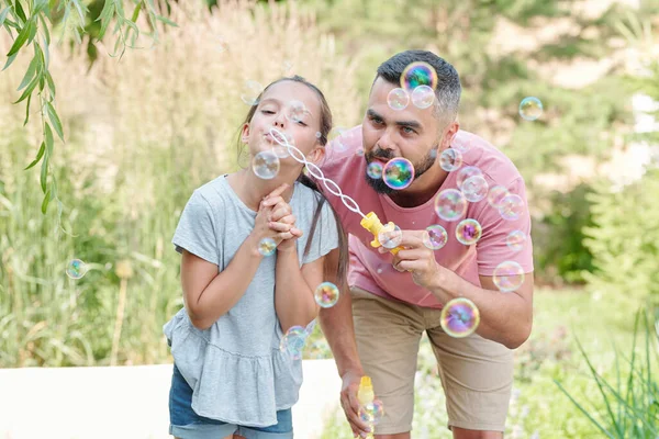 现代的成年父亲与女儿在户外吹肥皂泡 — 图库照片