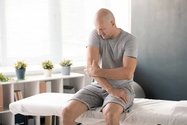 Hombre Calvo Tocando Codo Doloroso Tratando Masajearlo Antes Del Ejercicio — Foto de Stock