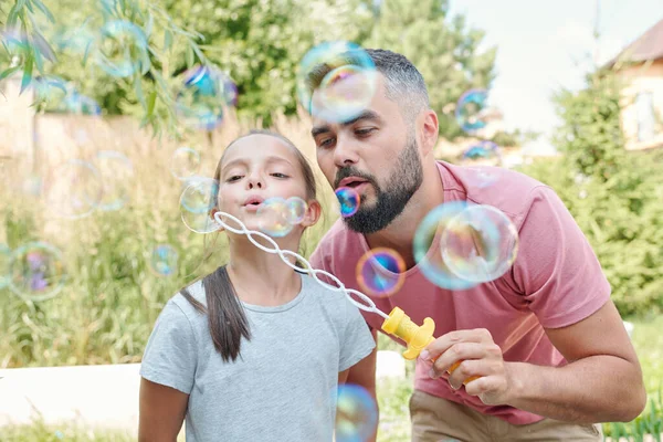 快乐的父亲和他可爱的女儿在户外吹泡泡 — 图库照片