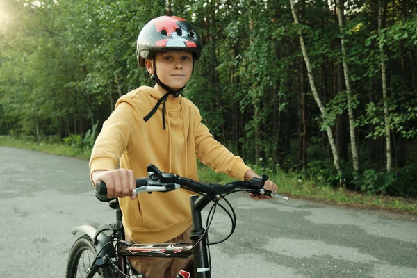 Fiatal Fiú Sárga Kapucnis Pulóverben Védősisakkal Kezében Kerékpárfogantyúkkal Miközben Úton — Stock Fotó