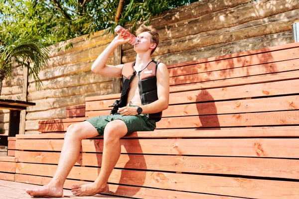 Young Athlete Shorts Safety Jacket Sitting Wooden Bench Sunny Day — Stock Photo, Image