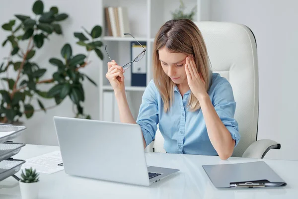 Young Tired Businesswoman Headache Touching Temple Bending Slightly Forwards Desk — Stock Photo, Image