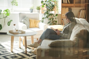 Dijital tablette internette sörf yapan genç ve güzel bir kadının yatay görüntüsü.