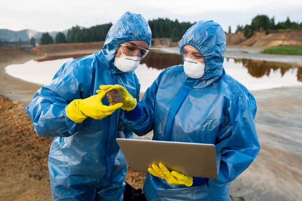 Jonge Wetenschapper Beschermende Overall Geeft Steen Aan Collega Met Laptop — Stockfoto