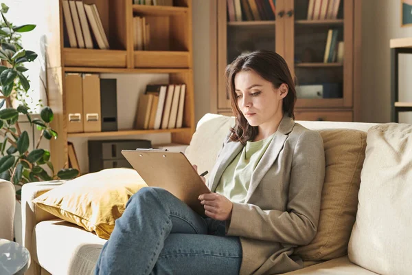 Aantrekkelijke Jonge Vrouw Zittend Bank Moderne Kantoor Kamer Met Klembord — Stockfoto