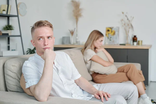 Mladý Muž Lhostejným Výrazem Tváři Sedí Gauči Ignoruje Svou Nešťastnou — Stock fotografie