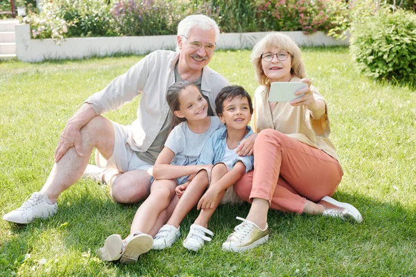 Seniorka Která Kameře Smartphonu Stará Sebe Svého Manžela Vnoučata — Stock fotografie