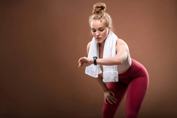 Unavená Mladá Blond Sportovkyně Activewear Při Pohledu Fitbit Zápěstí Zatímco — Stock fotografie