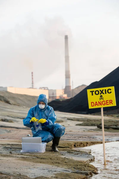 污染地区生态调查期间 当代生态学家将装有有毒土壤或水样本的瓶子装进垃圾袋中 — 图库照片