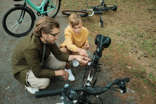 Söt Blond Pojke Gul Hoodie Tittar Detaljerna Cykeln Medan Hans — Stockfoto