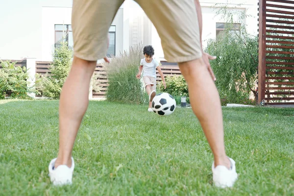 Hombre Irreconocible Jugando Fútbol Con Chico Activo Sobre Hierba Verde —  Fotos de Stock